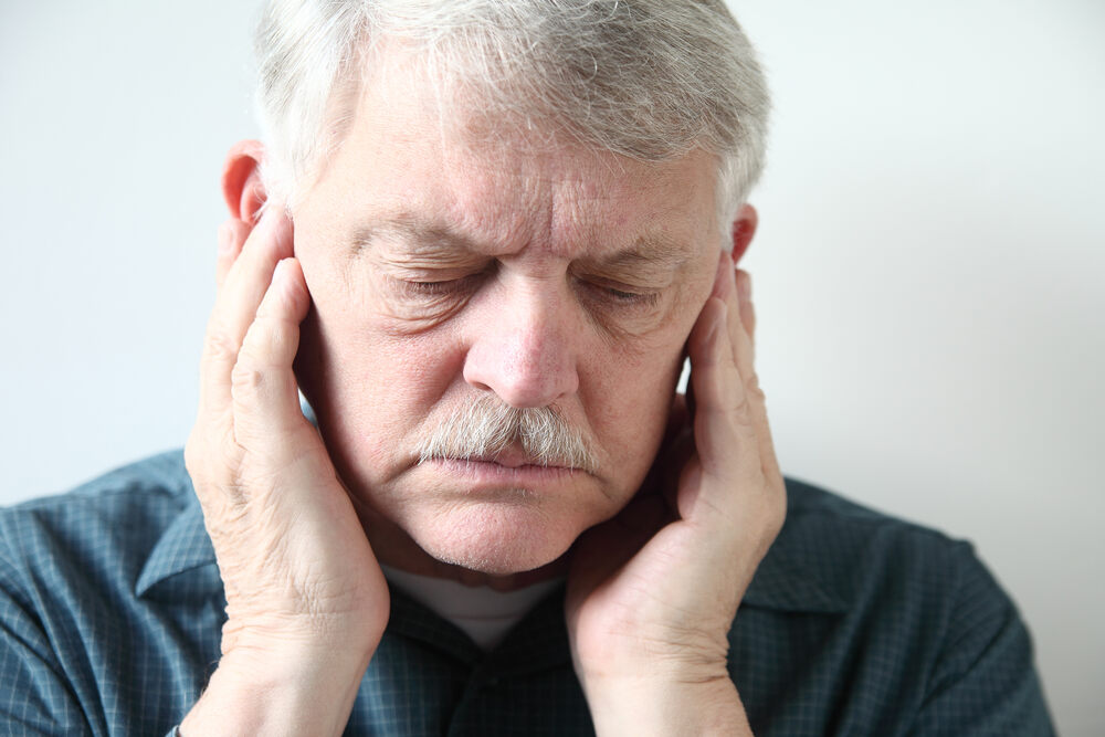 a man is suffering from TMJ pain